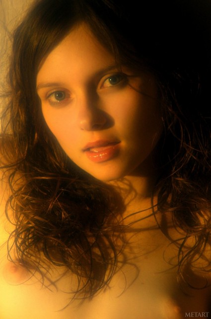 Anna sitting naked in a dark room