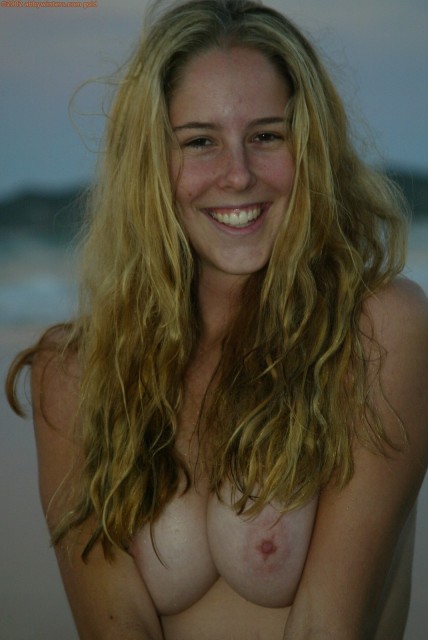 Happy blonde gets fully wet on a beach